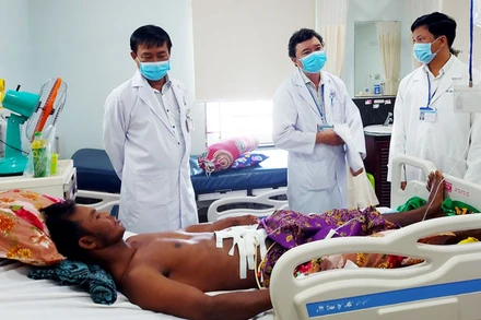 Các bác sĩ Bệnh viện đa khoa tỉnh Kiên Giang thăm khám sức khỏe ông Nhoem Slat, người bị trâu húc thủng bụng.
