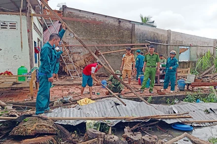 Cán bộ, chiến sĩ tích cực hỗ trợ người dân khắc phục hậu quả do mưa dông, lốc xoáy gây ra. (Ảnh: PHƯƠNG VŨ).