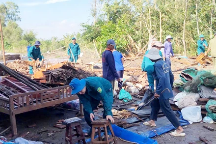 Cán bộ, chiến sĩ lực lượng vũ trang huyện Giồng Riềng khẩn trương hỗ trợ người dân khắc phục hậu quả do mưa dông, lốc xoáy gây ra.