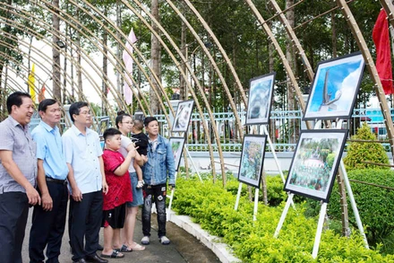 Người dân và chính quyền địa phương tham quan triển lãm ảnh. (Ảnh: HUỲNH LÃNH).