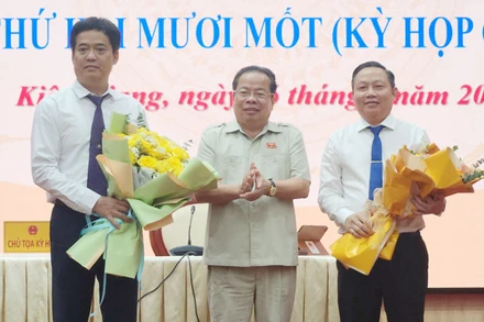 Chủ tịch Hội đồng nhân dân tỉnh Kiên Giang Mai Văn Huỳnh tặng hoa chúc mừng ông Lê Quốc Anh (bìa trái) và ông Lê Hữu Toàn (bìa phải).