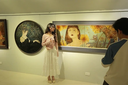 Khách tham quan chụp ảnh với các tác phẩm được triển lãm.