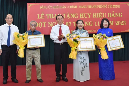 Đồng chí Nguyễn Văn Nên, Ủy viên Bộ Chính trị, Bí thư Thành ủy Thành phố Hồ Chí Minh và đồng chí Nguyễn Hồ Hải, Phó Bí thư Thành ủy chúc mừng đảng viên được nhận Huy hiệu Đảng.