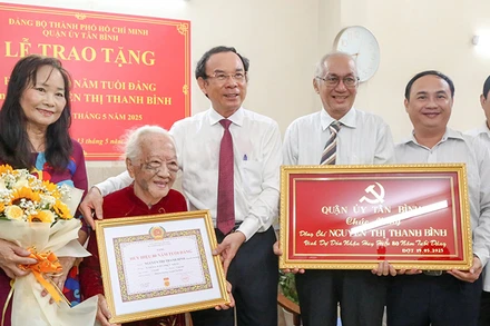 Đồng chí Nguyễn Văn Nên, Ủy viên Bộ Chính trị, Bí thư Thành ủy Thành phố Hồ Chí Minh chúc mừng Đảng viên Nguyễn Thị Thanh Bình nhận Huy hiệu 80 năm tuổi Đảng. (Ảnh L.T)