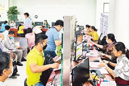 Ảnh minh họa: Cán bộ Văn phòng đăng ký đất đai thành phố Thủ Đức làm thủ tục hồ sơ nhà đất cho người dân.