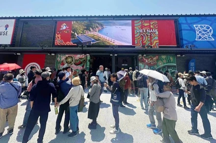 Khách tham quan xếp hàng vào thăm Nhà triển lãm Việt Nam tại EXPO 2025. 