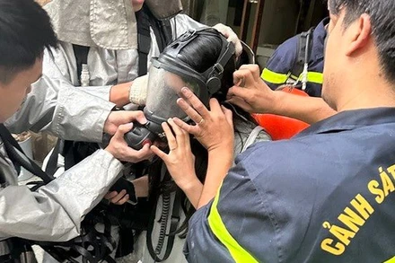 Lính cứu hoả hỗ trợ phụ nữ mang bầu thoát nạn khỏi khói khí độc hại trong đám cháy. (Ảnh: ANTD)