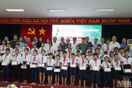 Nguyên lãnh đạo Trung ương, lãnh đạo địa phương và nhà tài trợ chụp hình với cho học sinh dân tộc thiểu số, học sinh nghèo khu vực biên giới tỉnh Long An.