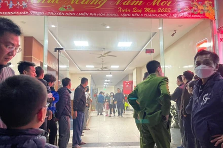 Cảnh sát hướng dẫn người dân thoát xuống sân chung cư trong đêm. (Ảnh: Đ.N)