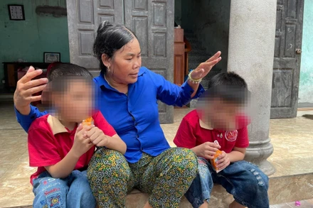 Bà Cúc và 2 người con không chung huyết thống Bảo Q., Bảo K. bên hiên nhà. 