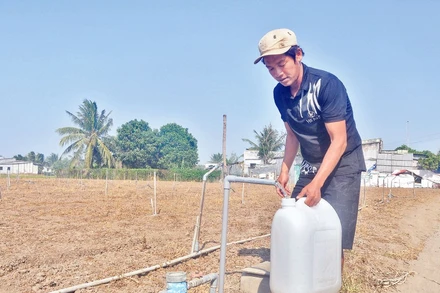 Ông Trương Tấn Lộc, xã Tân Điền, huyện Gò Công Đông (Tiền Giang) lấy nước miễn phí từ vòi nước công cộng.