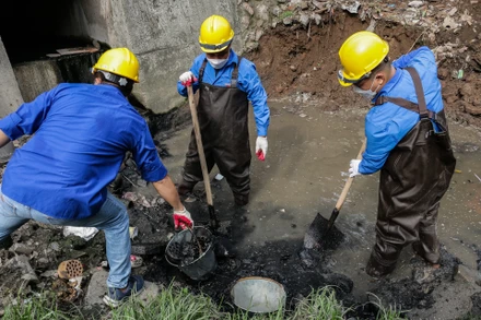 Đoàn viên, thanh niên Báo Nhân Dân và Công ty TNHH MTV Thoát nước Hà Nội tiến hành thu gom, dọn bùn, phế thải tại tuyến phân lũ sông Sét-Lừ. (Ảnh: Nam Nguyễn)