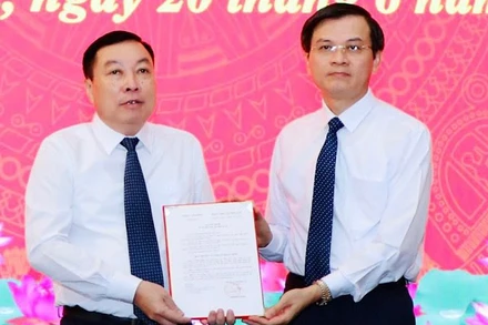 Đồng chí Đoàn Minh Huấn, Ủy viên Trung ương Đảng, Bí thư Tỉnh ủy Ninh Bình trao quyết định cho đồng chí Đinh Văn Tiên. (Ảnh: ĐỨC LAM)