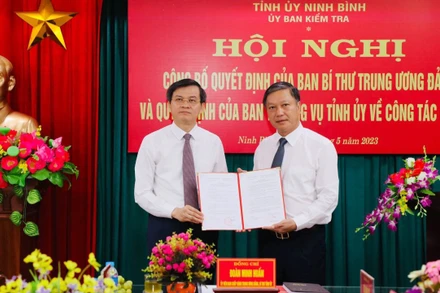 Đồng chí Đoàn Minh Huấn, Ủy viên Trung ương Đảng, Bí thư Tỉnh ủy Ninh Bình trao Quyết định của Ban Bí thư Trung ương Đảng cho đồng chí Đinh Việt Dũng. (Ảnh: ĐỨC LAM)