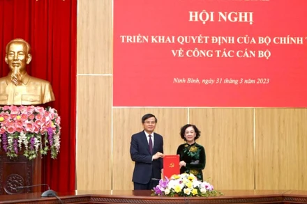 Thay mặt Bộ Chính trị, Ban Bí thư, đồng chí Trương Thị Mai, Ủy viên Bộ Chính trị, Thường trực Ban Bí thư, Trưởng Ban Tổ chức Trung ương trao quyết định và tặng hoa chúc mừng tân Bí thư Tỉnh ủy Ninh Bình Đoàn Minh Huấn. (Ảnh: Lê Hồng)