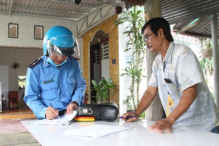 Lực lượng chức năng lập biên bản cam kết tháo dỡ công trình vi phạm hành lang bảo vệ cầu Tầm Vu trên quốc lộ 61.