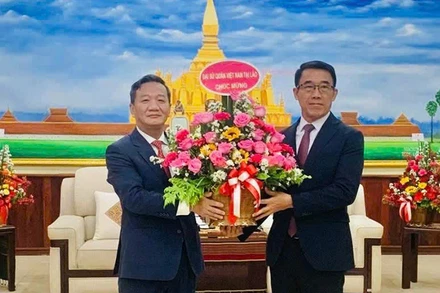 Đại sứ Nguyễn Minh Tâm chúc mừng Quyền Trưởng Ban Đối ngoại Trung ương Đảng Nhân dân Cách mạng Lào Bounlua Phandanouvong. (Ảnh: Cộng tác viên)