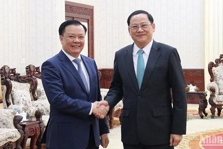 Bí thư Thành ủy Hà Nội Đinh Tiến Dũng (bên trái) và Thủ tướng Lào Sonexay Siphandone. (Ảnh: TRỊNH DŨNG)