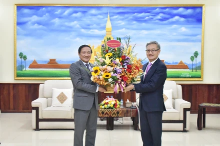 Đại sứ Nguyễn Bá Hùng chúc mừng Trưởng Ban Đối ngoại Trung ương Đảng Nhân dân Cách mạng Lào Thongsavanh Phomvihane. (Ảnh: Trịnh Dũng)