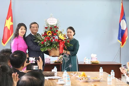 Đại sứ Nguyễn Minh Tâm tặng hoa chúc mừng tập thể cán bộ, nhân viên nhà trường. Ảnh: HẢI TIẾN