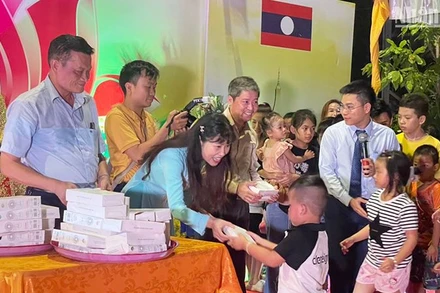 Ban tổ chức trao quà cho các cháu thiếu nhi là con em cộng đồng người Việt Nam tại Lào. (Ảnh: HẢI TIẾN)