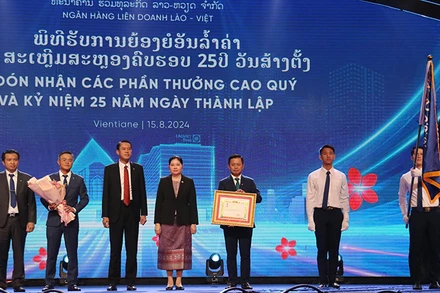 Ngân hàng liên doanh Lào-Việt đón nhận Huân chương Lao động hạng Nhất của Lào. (Ảnh: Hải Tiến)