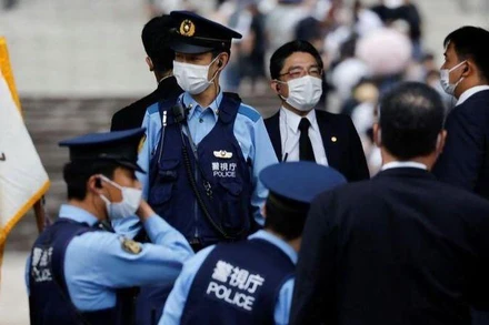 Cảnh sát làm nhiệm vụ trong lúc người dân xếp hàng để đặt hoa tưởng nhớ ông Abe tại đền Zojoji. (Ảnh: Reuters)