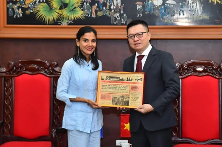 Tổng Biên tập Báo Nhân Dân Lê Quốc Minh nhận quà lưu niệm của Phó Tổng Biên tập Báo Granma Arlin Alberty Loforte. (Ảnh: THỦY NGUYÊN)