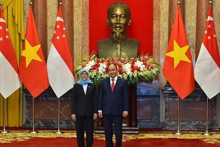 Chủ tịch nước Nguyễn Xuân Phúc và Tổng thống Singapore Halimah Yacob chụp ảnh chung tại lễ đón. (Ảnh: Thủy Nguyên)