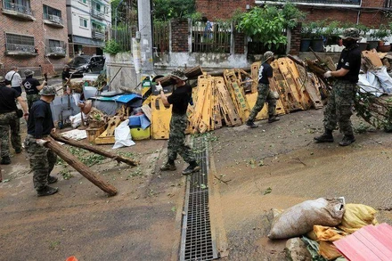 Binh sĩ dọn dẹp đường phố Seoul sau trận mưa kỷ lục ngày 9/8. (Ảnh: Yonhap)