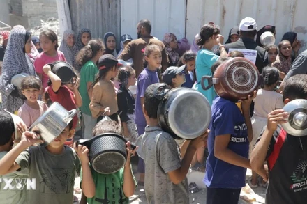 Trẻ em xếp hàng nhận thức ăn cứu trợ tại trại tị nạn Jabalia ở Dải Gaza. (Ảnh: THX/TTXVN)