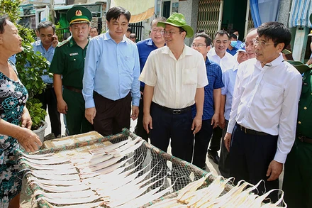 Phó Bí thư Thành ủy Thành phố Hồ Chí Minh Nguyễn Hồ Hải (áo trắng đội mũ) trò chuyện cùng người dân trên xã đảo Thạnh An, huyện Cần Giờ. (Ảnh: HOÀNG TRIỀU)