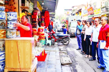Ban Chỉ đạo 197 phường Hàng Gai (Hoàn Kiếm) tuyên truyền, vận động các hộ dân trên tuyến phố Hàng Quạt không kinh doanh lấn chiếm vỉa hè, lòng đường. (Ảnh: CÔNG THỌ) 