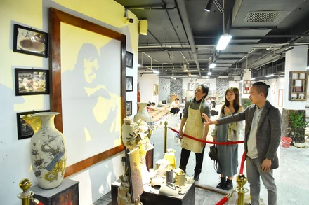 Nghệ nhân Bùi Văn Tự giới thiệu với khách tham quan về tác phẩm Nỗi suy tư nghề gốm được trưng bày tại Trung tâm Tinh hoa làng nghề Việt. (Ảnh: THỦY NGUYÊN)