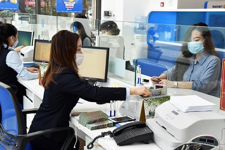 Khách hàng giao dịch tại Ngân hàng Bảo Việt (Hà Nội). (Ảnh: TRẦN HẢI)