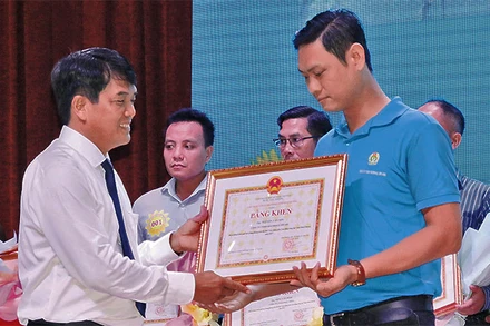 Trưởng ban Dân vận Tỉnh ủy Bình Dương Bùi Thanh Nhân trao Bằng khen của Chủ tịch Ủy ban nhân dân tỉnh tặng lao động giỏi, lao động sáng tạo.