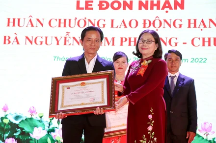Đại diện Công ty TNHH Lan Anh (bên trái) nhận Huân chương Lao động hạng ba.