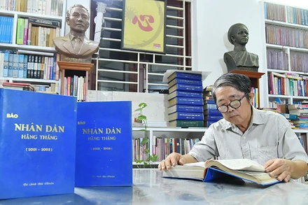 Nhà báo Mai Sông Bé với các số báo Nhân Dân hằng tháng mà ông đã dày công sưu tầm và đóng thành quyển để lưu giữ.