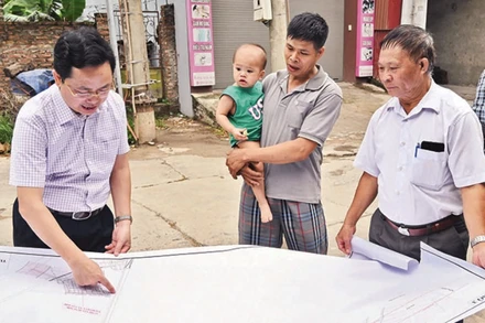 Cán bộ Trung tâm Phát triển quỹ đất huyện Mê Linh khảo sát thực địa công tác giải phóng mặt bằng đường vành đai 4 đoạn qua xóm Trại A, thôn Khuê Ngoại, xã Văn Khê. (Ảnh: DUY LINH)