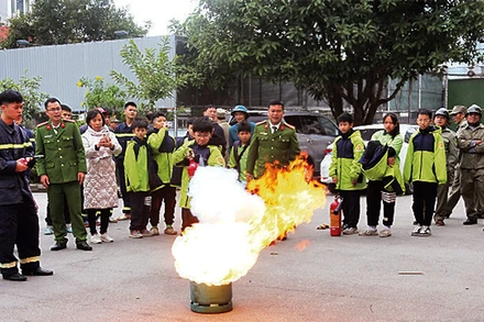 Học sinh và người dân TP Lạng Sơn trải nghiệm, thực hành sử dụng bình chữa cháy. (Ảnh: HOÀNG HUẤN)