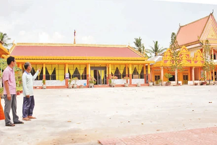 Một phần ngôi chùa Sóc Ven do ông Danh Hùng (người chỉ tay) thiết kế, xây dựng.