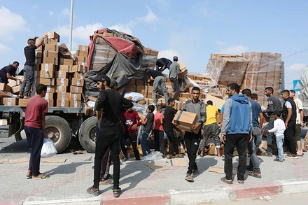Người dân chuyển hàng cứu trợ nhân đạo tại cửa khẩu Rafah ở Dải Gaza.