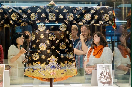 Du khách chiêm ngưỡng áo Nhật Bình cung tần triều Nguyễn tại Bảo tàng Cổ vật Cung đình Huế. (Ảnh: TRUNG TÂM BẢO TỒN DI TÍCH CỐ ĐÔ HUẾ)