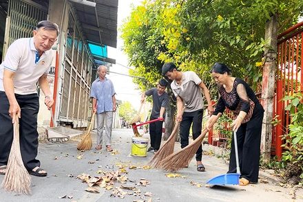 Cán bộ Mặt trận phường Trường Thọ, thành phố Thủ Đức và người dân dọn dẹp vệ sinh tuyến đường trên địa bàn.