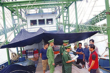 Bộ đội Biên phòng Quảng Trị tuyên truyền chống khai thác hải sản bất hợp pháp cho ngư dân. (Ảnh: HM)