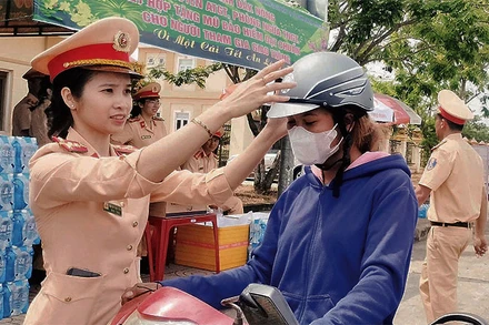 Lực lượng Cảnh sát giao thông Công an tỉnh Đắk Nông trao mũ bảo hiểm tặng người dân trên đường về quê đón Tết.