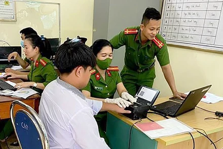 Cán bộ Công an thành phố Yên Bái, tỉnh Yên Bái hướng dẫn người dân đăng ký tài khoản định danh điện tử cấp độ 2 và phòng ngừa các thủ đoạn của tội phạm công nghệ cao. (Ảnh: THANH SƠN)