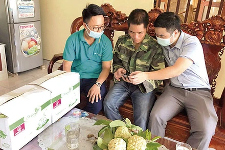 Nhân viên ViettelPost hướng dẫn người dân xã Chi Lăng cách vận hành cửa hàng số trên sàn thương mại điện tử voso.vn. (Ảnh: HOÀNG VƯƠNG)