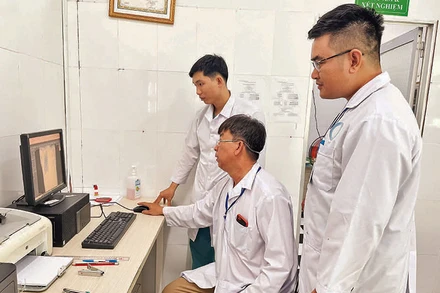 Các bác sĩ Trạm Y tế xã Thạnh An chẩn đoán tình trạng bệnh từ hình ảnh trên máy tính.