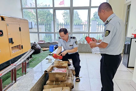 Cán bộ Cục Quản lý thị trường Hà Nội kiểm tra các thiết bị PCCC có dấu hiệu nhập lậu của một cơ sở kinh doanh tại huyện Thanh Trì, Hà Nội. (Ảnh: QUYÊN LƯU)